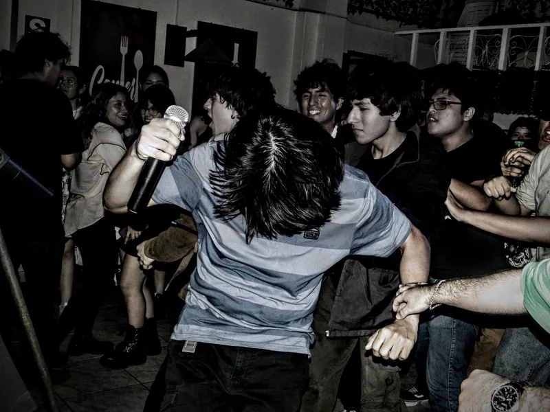 Pogo entre el público durante un show, en blanco y negro.