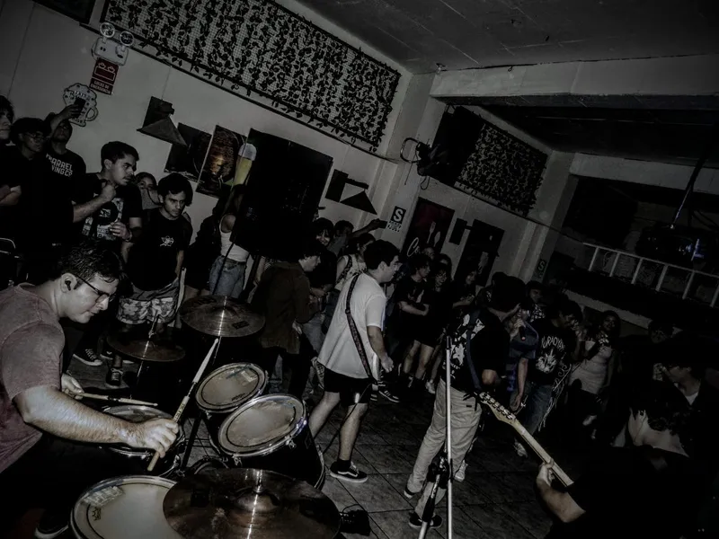 La banda tocando en una sala con el público alrededor.